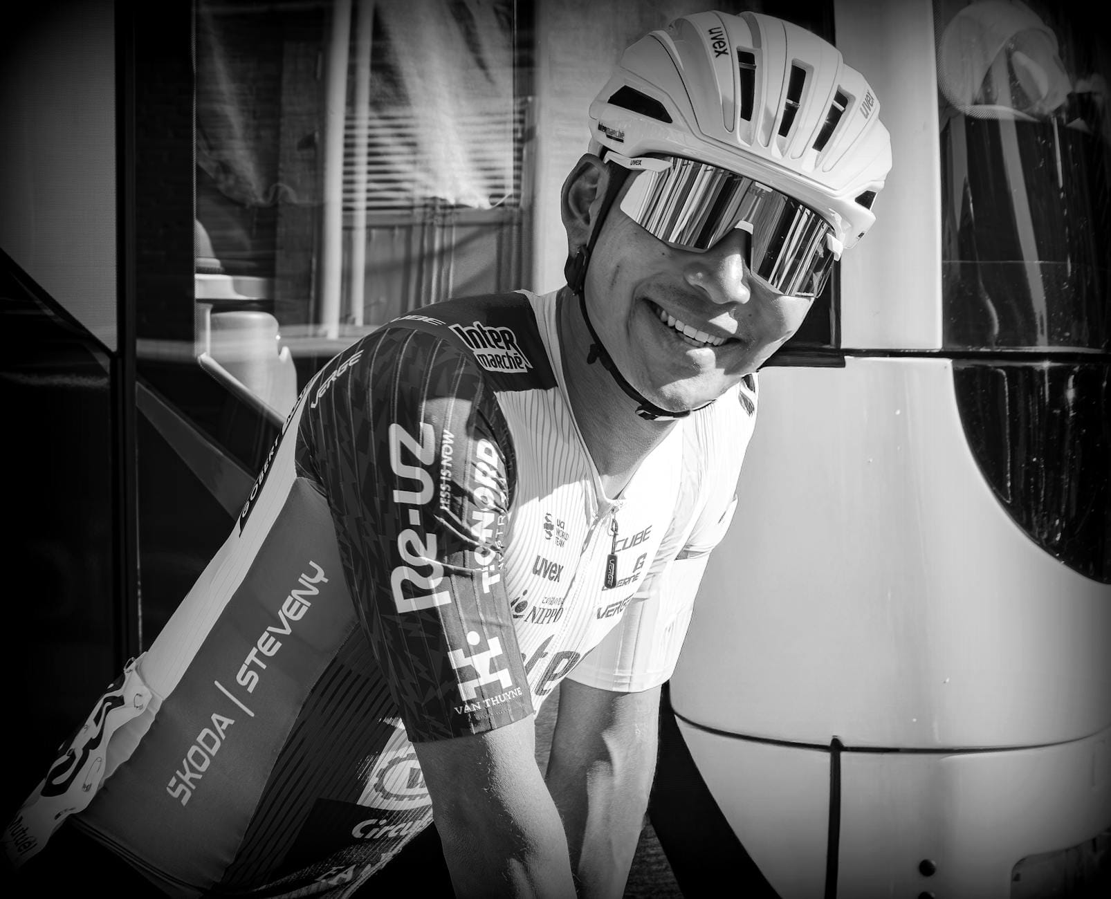 Uśmiechnięty rowerzysta w stroju kolarskim i kasku na zewnątrz