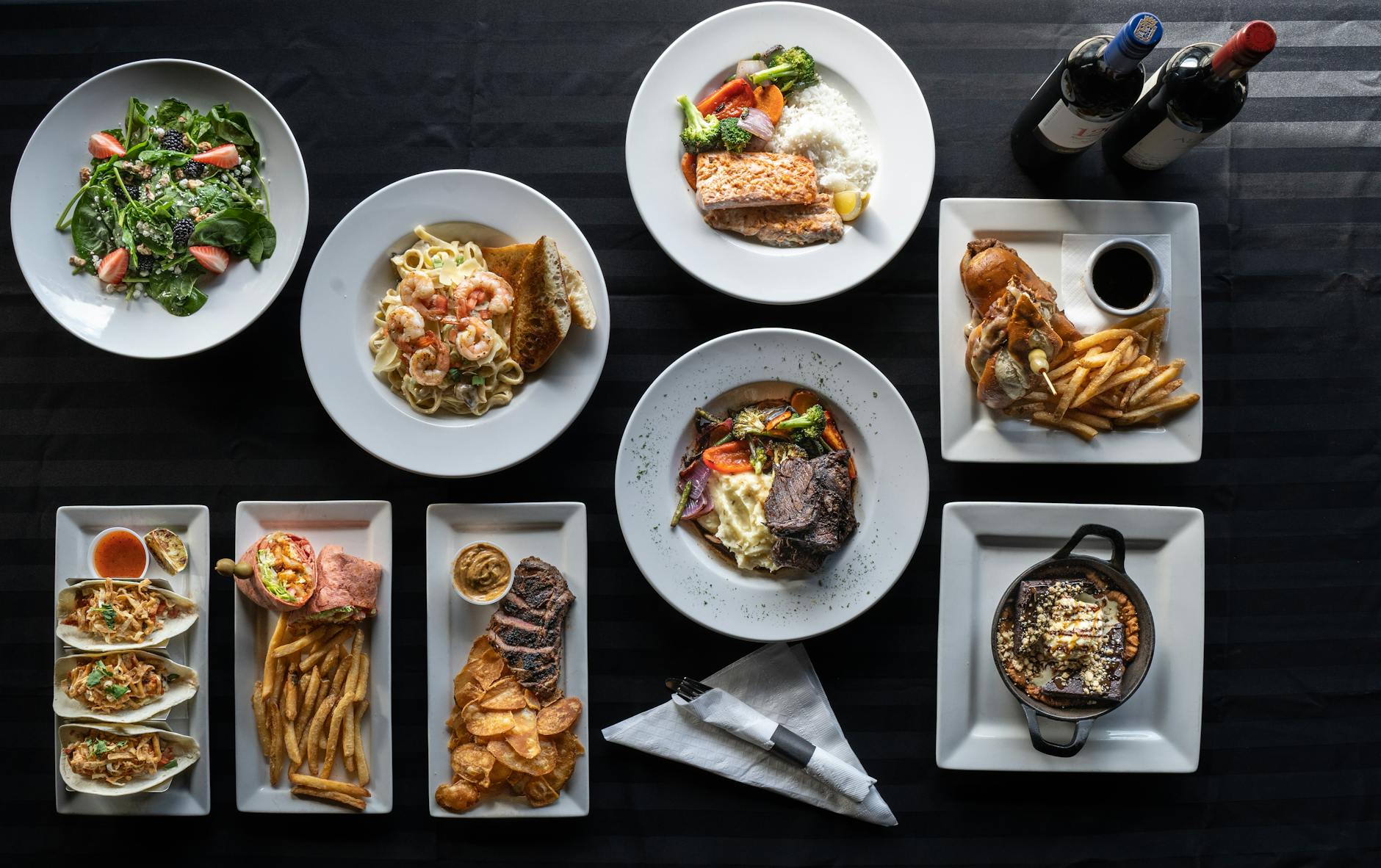 Elegancko podane dania kuchni restauracyjnej z butelkami wina z góry