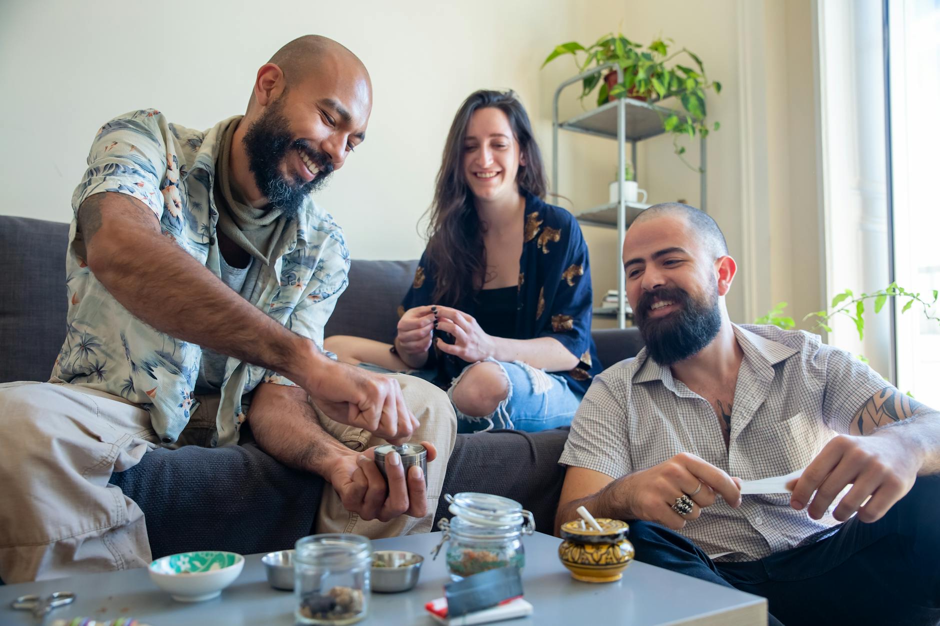 Grupa przyjaciół siedzi na kanapie z kawą w przytulnym salonie