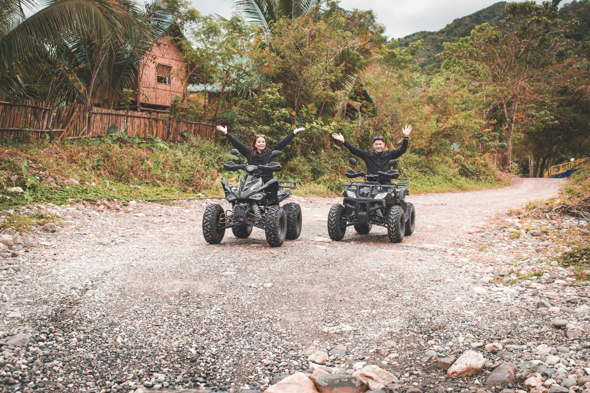 Para na quadach jedzie wiejską drogą wśród zieleni podczas weekendu