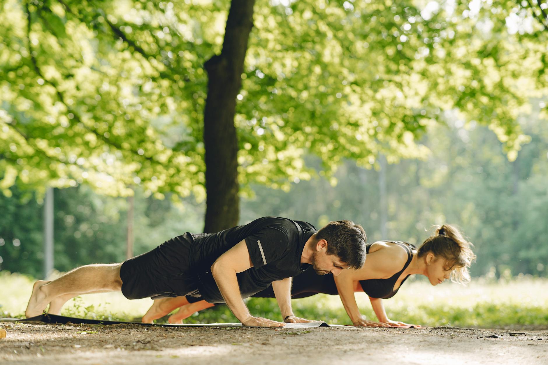 Para robiąca pompki w słonecznym parku jako forma aktywności outdoors