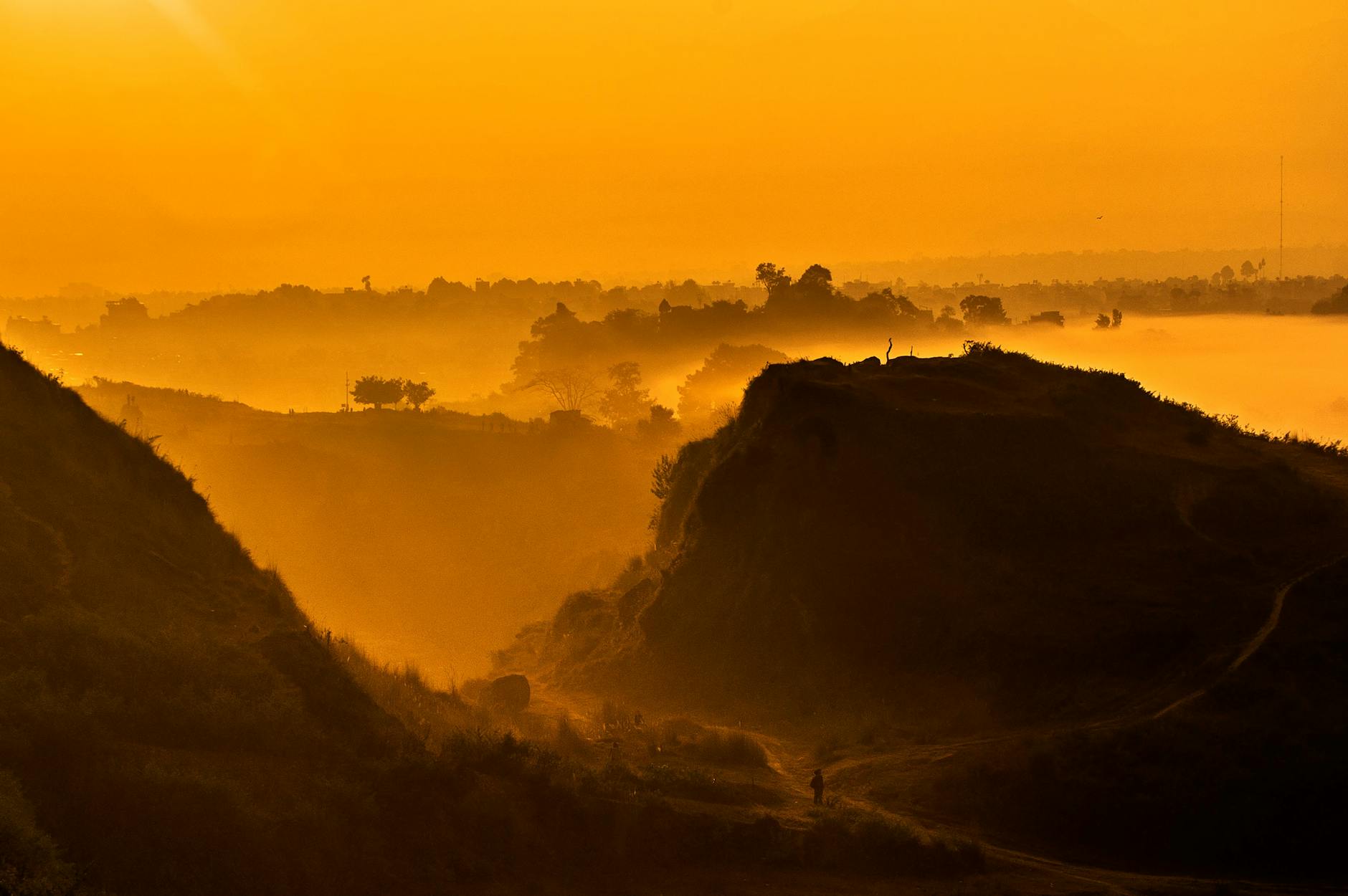 Złoty wschód słońca nad wzgórzami Kirtipur i mglistą doliną