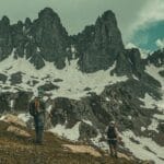 Dwóch mężczyzn na zimowym szlaku w zaśnieżonych górach