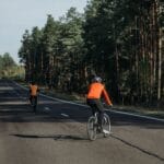 Grupa rowerzystów na malowniczej leśnej trasie w słoneczny dzień