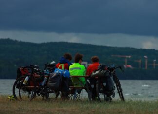 Pierwsze 100 km na rowerze w jeden dzień: jak rozłożyć siły, tempo i postoje Grupa rowerzystów odpoczywa nad jeziorem w Jönköping w Szwecji